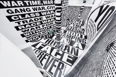 A tiny man in a space whose walls and floor are covered in text.