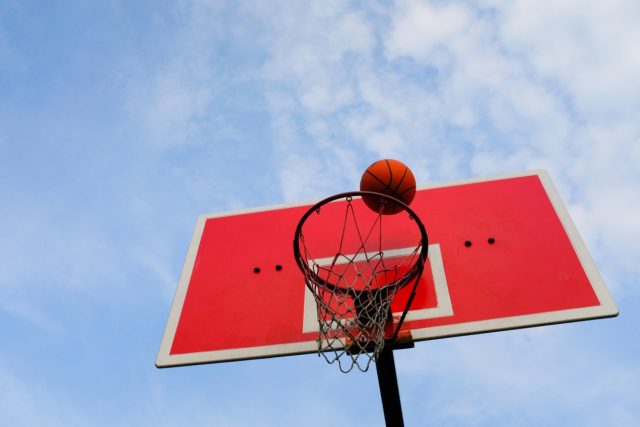 Bluesky-takes-on-Sports-Twitter-with-NBA-playoff-feature.jpg a basketball flies into the basket, against the blue sky, in an open area.