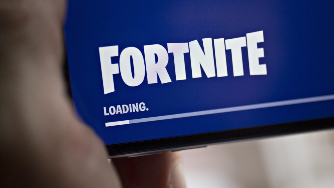 Fortnite-will-return-to-iOS-as-court-slams-Apples-interference.jpg Extreme close-up photograph of a hand holding a smartphone.