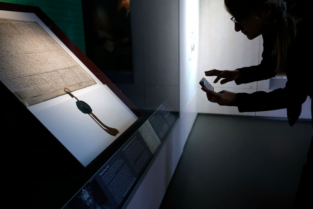 Harvards-Magna-Carta-Listed-as-Unofficial-for-80-Years-is.jpg LONDON, ENGLAND - SEPTEMBER 20: A museum visitor takes a photograph of The City of London Corporation’s 1297 copy of Magna Carta on display at its Heritage Gallery within Guildhall Art Gallery on September 20, 2022 in London, England. "One of the finest surviving 13th-century copies of this historic document, it has been on rare public display for the last few months and returns to London Metropolitan Archives on Thursday," according to the museum. (Photo by Chip Somodevilla/Getty Images)