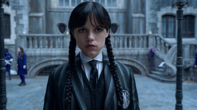 Netflix-will-show-generative-AI-ads-midway-through-streams-in.jpg young dark-haired girl in pigtails wearing a black school uniform looking dour