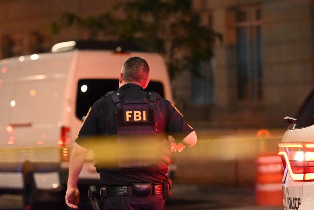 A man wearing body armor with his back turned.