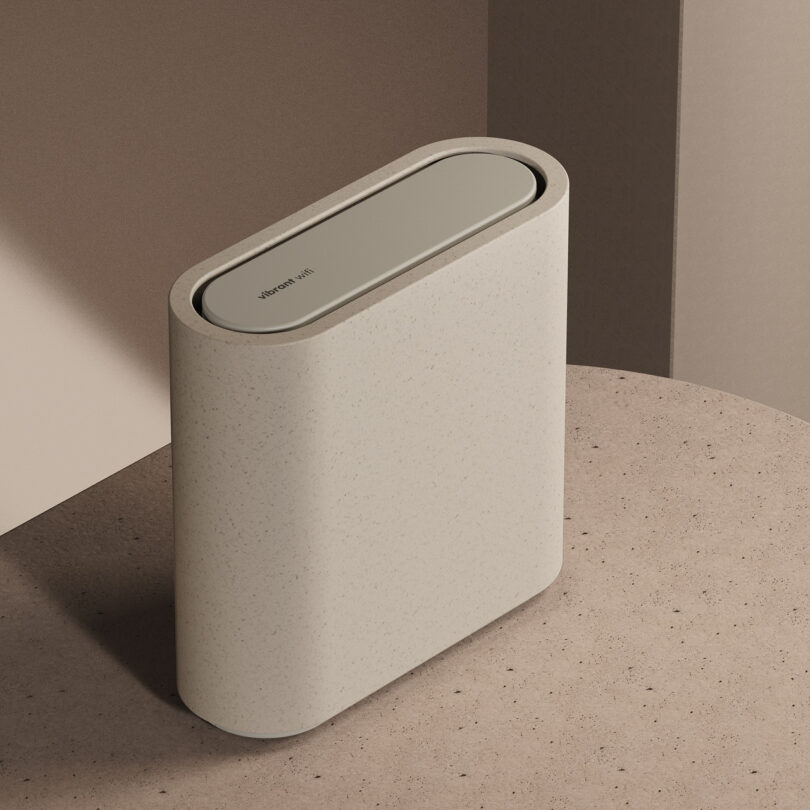 A beige air purifier with a sleek, rounded rectangular design, placed on a textured surface against a neutral background.