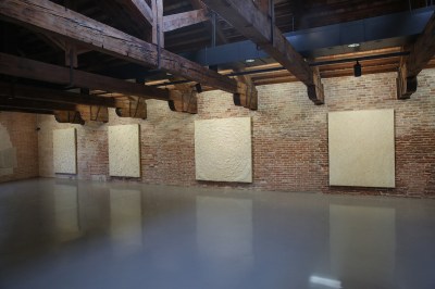 A group of abstract paintings hung on a wall.