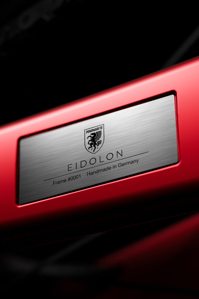 Close-up of a nameplate on a red surface, labeled 
