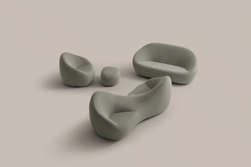 Four modern, minimalist gray upholstered furniture pieces—a sofa, a loveseat, an armchair, and an ottoman—are arranged on a plain beige background.