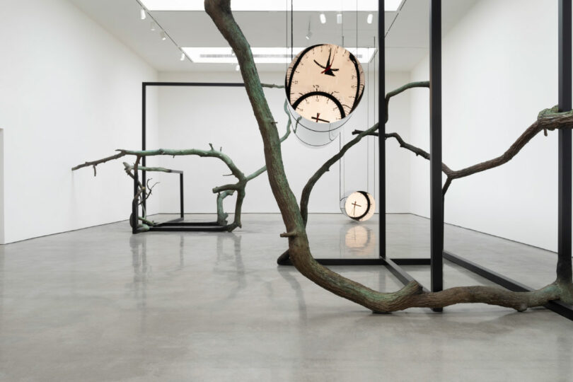 Gallery with organic bronze sculptures holding clocks