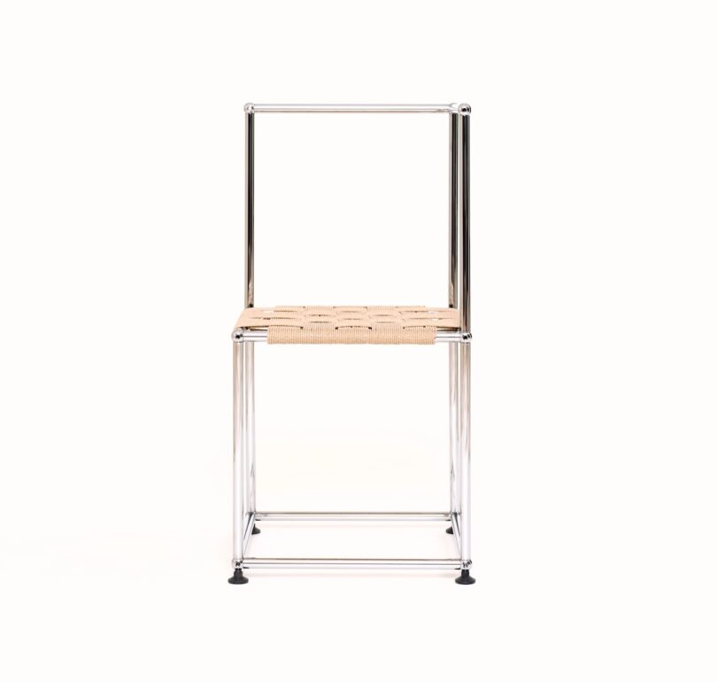 A metal-framed chair with a square woven seat and no backrest or armrests, shown against a plain white background.