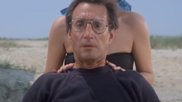 1750700883_A-shark-scientist-reflects-on-Jaws-at-50.jpg closeup of man in glasses on the beach looking out to the water with growing horror