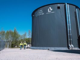 Two technicians walk by the Pornainen sand battery.