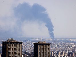 TOPSHOT - Smoke billows in the distance from an oil refinery following an Israeli strike on the Iranian capital Tehran on June 17, 2025. Israel and Iran exchanged fire again, the fifth day of strikes in their most intense confrontation in history, fuelling fears of a drawn-out conflict that could engulf the Middle East. (Photo by ATTA KENARE / AFP) (Photo by ATTA KENARE/AFP via Getty Images)