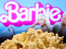 A popcorn and Barbie movie website displayed on a screen in the background are seen in this illustration photo taken in Krakow, Poland on August 1, 2023.