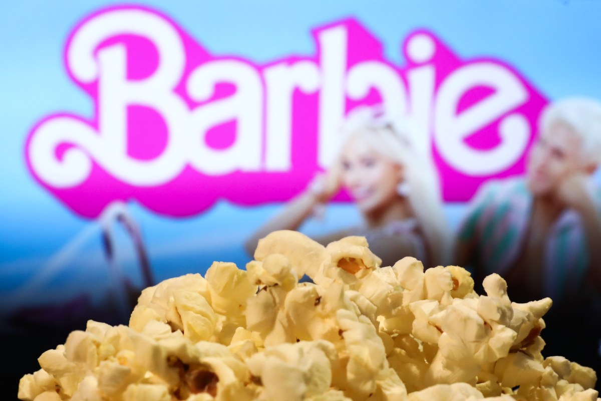 OpenAI-and-Barbie-maker-Mattel-team-up-to-bring-generative-AI.jpg A popcorn and Barbie movie website displayed on a screen in the background are seen in this illustration photo taken in Krakow, Poland on August 1, 2023.