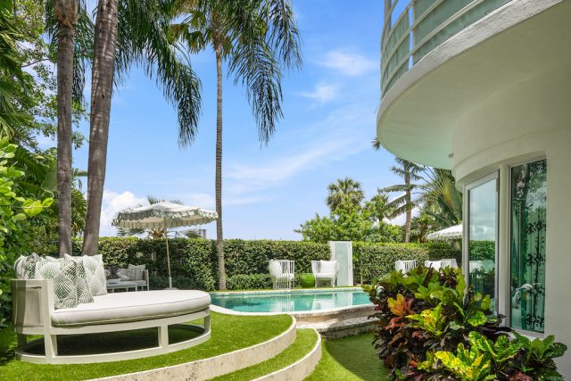 Pace-CEO-Marc-Glimchers-Palm-Beach-Home-Sells-to-Former.jpg The facade of a home and a swimming pool surrounded by palm trees.
