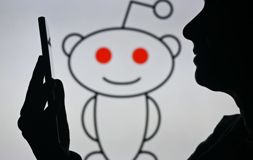 Reddit-CEO-pledges-site-will-remain-written-by-humans-and.jpg An image of a woman holding a cell phone in front of the Reddit logo displayed on a computer screen, on April 29, 2024, in Edmonton, Canada.