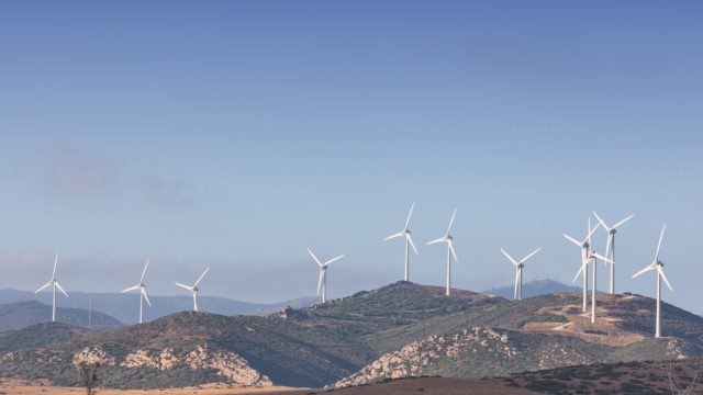 Spanish-blackout-report-Power-plants-meant-to-stabilize-voltage-didnt.jpg Image of a dry, brown hillside with lots of small scrub, and white wind turbines in the background.