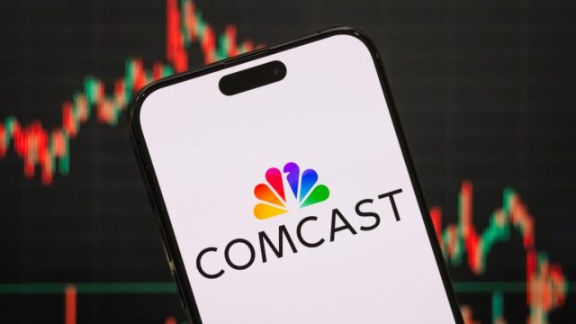Stung-by-customer-losses-Comcast-says-all-its-new-plans.jpg A Comcast logo displayed on a smartphone screen with a stock chart in the background.