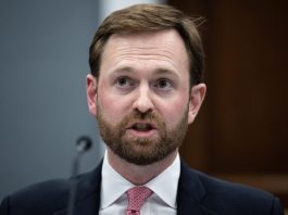 FTC Chairman Andrew Ferguson speaking into a microphone while sitting at a table.