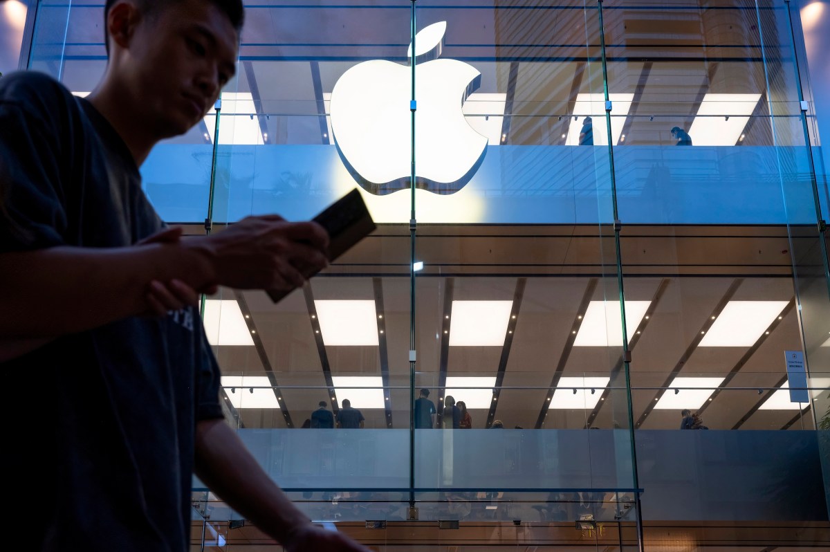 iOS-19-All-the-rumored-changes-Apple-could-be-bringing.jpg A pedestrian uses a smartphone while walking past an Apple store and logo in Hong Kong.