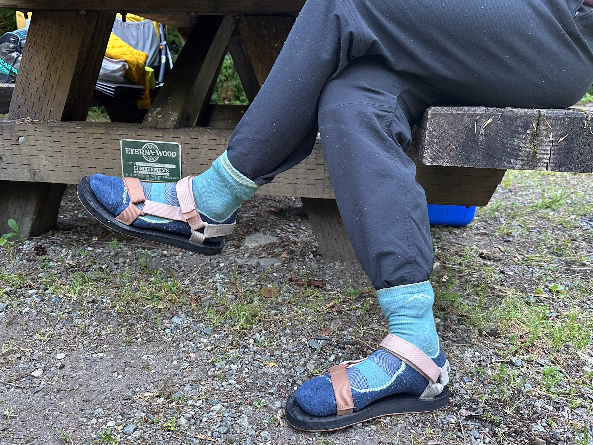 the author wears the original universal sandals with socks while sitting at a picnic bench