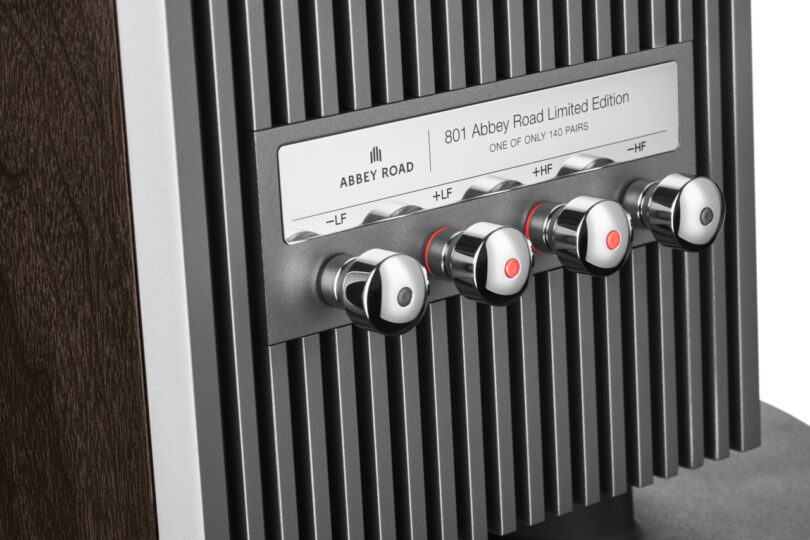 Close-up of four chrome Bowers & Wilkins control knobs on a ribbed metal panel labeled 