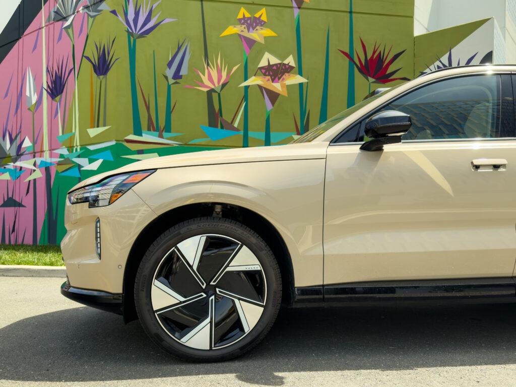 The front of a Volvo EX90 in front of a mural