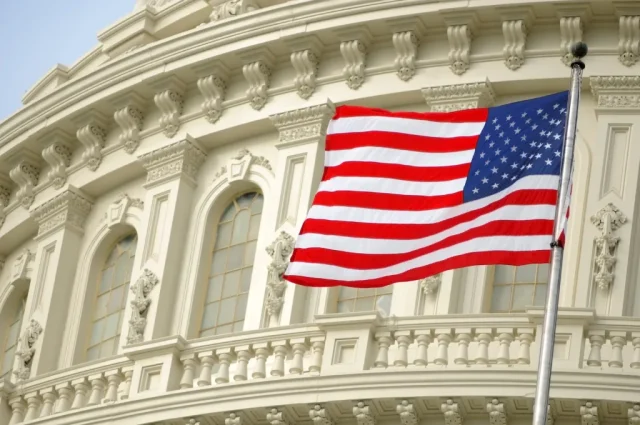 9-Ways-it-Impacts-Travel.jpeg A flag flying next to the U.S. Capitol