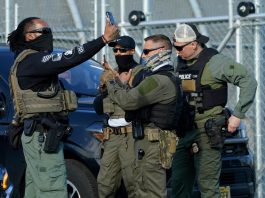Immigration and Customs Enforcement (ICE) agents use their phones near protestors at a demonstration in Elizabeth, New Jersey May 7, 2025, outside Delaney Hall, a newly converted immigrant detention centre.