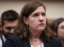 FTC Commissioner Rebecca Kelly Slaughter sits at a table during a Congressional committee hearing.
