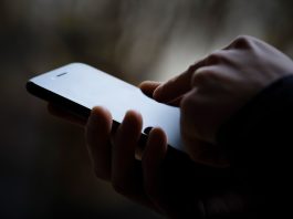 A photo of a person's phone in someone's hand, the image is darkened.