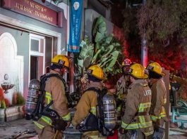 firefights standing outside museum building at night in Los angeles.