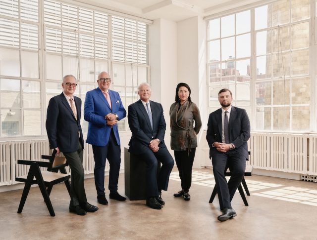 Four men and a woman in a sun filled loft.