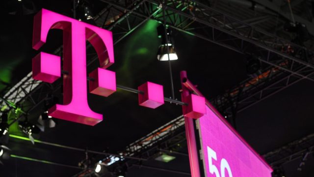 T-Mobile-follows-orders-from-Trump-FCC-ends-DEI-to-get.jpg A large T-Mobile logo and a 5G poster hanging above a conference hall.