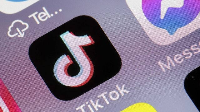 TikTok-is-being-flooded-with-racist-AI-videos-generated-by.jpg A TikTok app icon on a phone screen.
