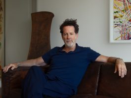 Portrait of a man with curly hair and a salt and pepper beard.