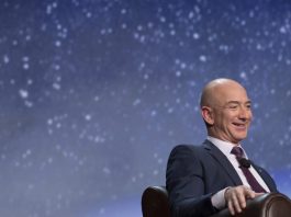 Jeff Bezos at a space conference, sitting in front of a picture of the stars in the night sky.